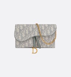 The Saddle pouch with chain, crafted in gray Dior Oblique jacquard, is a hybrid creation with a both modern and streamlined design. The accessory has an asymmetrical flap featuring an antique gold-finish metal D stirrup. Thanks to its detachable chain strap, the small pouch may be worn over the shoulder, crossbody or carried by hand.. Dior Wallet On Chain, Gris Dior, Tas Lv, Dior Purse, Wallet With Chain, Dior Oblique, Christian Dior Couture, Fancy Bags, Designer Wallets