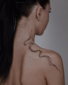 the back of a woman's neck with a tattoo on it