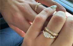 a man and woman holding hands with wedding rings on their fingers, in the backseat of a car