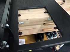 the inside of a toolbox with shoes in it and some screws on the side