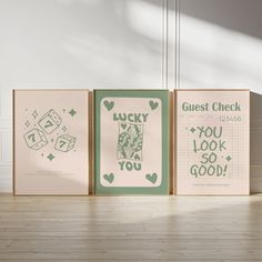 three framed posters with words on them sitting on a wooden floor in front of a white wall