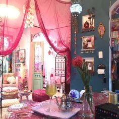 a room filled with lots of furniture and decor on top of a pink table cloth