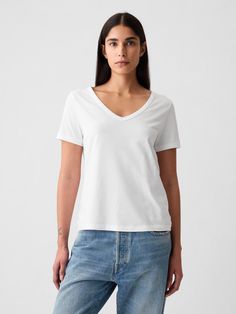 Made with 100% organically grown cotton.  Organic cotton is better for people and the environment because it’s grown without the use of harmful synthetic pesticides and fertilizers.  Short sleeves.  V-neck.  Straight silhouette with a relaxed fit.  Hits at the hip.  Nissa is 5’9. 5”/177cm with a 31”/79cm chest, 24”/61cm waist, 35”/89cm hip wearing a regular Gap Weather Clothes, Lc Waikiki, Warm Weather Outfits, Pesticides, The Environment, Vintage Knitting, Petite Size, Warm Weather, V Neck T Shirt