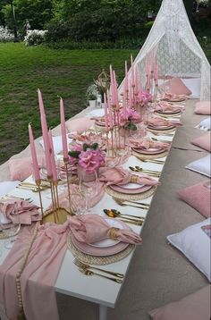 the table is set with pink napkins and place settings for an elegant dinner party