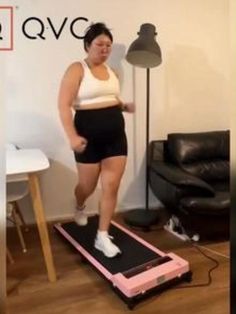 a woman is standing on a treadmill