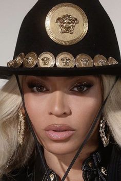 a close up of a person wearing a black hat with gold buttons on the brim