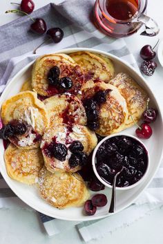 crepes with berries and powdered sugar in a white bowl on a table