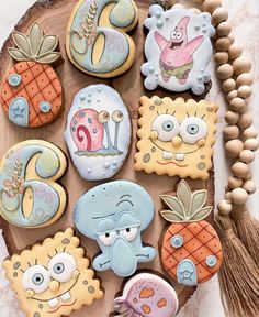 decorated cookies are arranged on a wooden platter