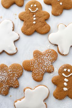 several ginger cookies with icing and sprinkles are arranged on a white surface