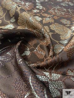 the fabric is brown and has gold flowers on it, as well as an intricate design