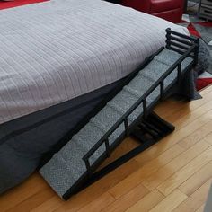 a bed sitting on top of a wooden floor next to a red chair