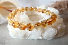 Citrine is one of the most powerful stones for manifestation and is known for new beginnings. It is often used to assist in manifesting abundance, luck, and new opportunities. Not only does this ray of sunshine bring joy and happiness, but it also attracts prosperity, balances emotions and can elevate your self-worth and self-esteem. Since Citrine is strongly connected to the Solar Plexus Chakra, it can help boost confidence and cultivate personal power. Let its bright gold energy lift you up an Cheap Yellow Crystal Bracelet For Gift, Healing Citrine Gemstone Beads Bracelet, Spiritual Citrine Crystal Bracelet With Gemstone Beads, Adjustable Citrine Crystal Bracelet For Healing, Spiritual Citrine Crystal Bracelet With Natural Stones, Healing Citrine Crystal Bracelet With Round Beads, Spiritual Adjustable Citrine Beaded Bracelets, Spiritual Citrine Beaded Bracelets For Healing, Spiritual Orange Crystal Bracelet With Gemstone Beads