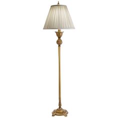 a gold floor lamp with a white shade