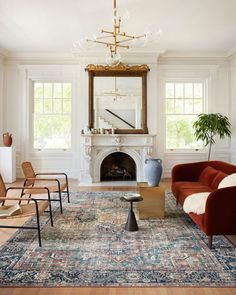 a living room filled with furniture and a fire place next to a mirror on the wall