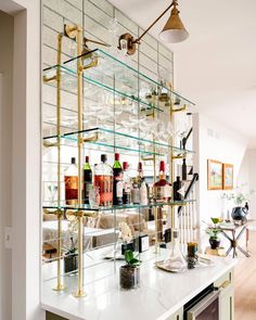 a bar with lots of liquor bottles and glasses on it's glass shelving