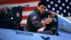 a man sitting in the cockpit of an airplane giving a thumbs up sign to someone