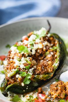 stuffed poblano peppers with ground beef and feta cheese in a white bowl