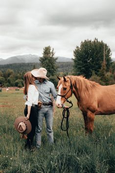 a man and woman standing next to a brown horse