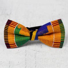 Designed by Ghana's Deborah Osei Boakye this delightful bow tie celebrates traditional African handicrafts. Local artisans hand-weave cotton kente cloth in vibrant colors sewn to make this striking bow tie. An elastic strap circles the neck so this accessory does not have to be tied. Multicolor Bow Tie For Summer Gift, Fitted Multicolor Bow Tie For Gift, African Handicrafts, African Love, Reverse Painted Glass, Kente Cloth, Reverse Painted, Premium Gift, Womens Fashion For Work