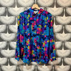 Very cool Vintage Blouse with bright, vibrant colors. Era: 1990's Made in the U.S.A. Size: L MEASUREMENTS Shoulder to shoulder - 17 1/2" Sleeves - 23" Pit to pit - 20" Length, front of collar to hem - 25 1/5" In perfect and like new condition I believe in fashion that is timeless not fast. Vintage clothing has a level of quality that today's clothes do not embody. Not only can it be timeless but can be reused for years to come. It's not only time to buy better quality but it is time to reduce, r Fitted Multicolor Shirt With Color Block, Vibrant Blue Tops With Colorful Pattern, Vibrant Multicolor Blouse With Bold Print, Bold Multicolor Blouse With Vibrant Print, Retro Multicolor Blouse With Colorful Pattern, Retro Multicolor Tops With Vibrant Print, Vibrant Blue Top With Colorful Pattern, Retro Blue Top With Colorful Pattern, Vibrant Multicolor Blouse With Abstract Print