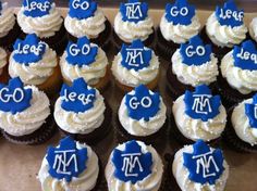 cupcakes with blue icing and white frosting are arranged on a tray