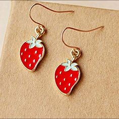 a pair of earrings with a strawberry on it