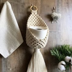 two white towels hanging on the wall next to a potted plant and cotton balls