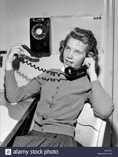 a woman sitting in a chair while talking on the phone