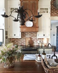 a kitchen with white cabinets and an old fashioned chandelier hanging from the ceiling