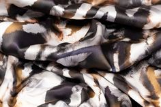 the fabric is very colorful and has black, white, and brown designs on it