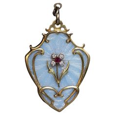 Circa 1910 This very large ornate 14K gold locket pendant is designed in Art Nouveau taste of the period. The pendant is embellished with excellent bluish white guilloche enamel. The center is applied with a ruby and diamond flower. The interior is fitted with a glazed picture frame. The enamel plaque is signed on the back under the enamel, likely by the maker. The pendant is unmarked but almost certainly is Russian. The rings (not original to the pendant) are marked with Russian 1908-1917 gold mark for 56 zolotnik standard and maker’s initials. The pendant measures (without rings) 57 x 39 mm (2 1/4 x 1 9/16 in.) Weight is 37.27 grams. Sold without chain Rose Gold Locket, Large Locket, Enamel Locket, Bijoux Art Nouveau, Victorian Locket, Art Nouveau Antiques, Guilloche Enamel, Antique Locket, Vintage Jewellery Rings