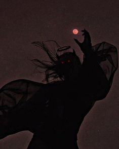 the silhouette of a woman with long hair and red eyes, holding her arms up in the air