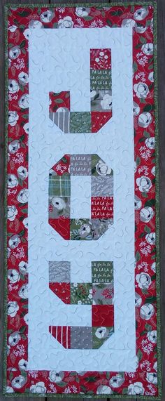 a quilted wall hanging with the letter e on it