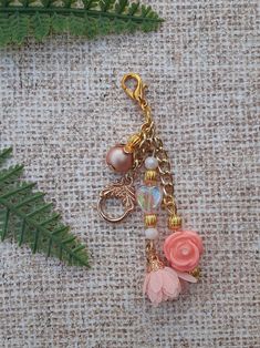 a close up of a keychain on a table with a plant and other items