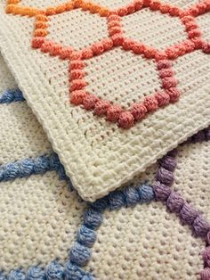 two crocheted rugs on top of each other with different colors and shapes