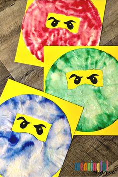 four different colored paper plates with faces painted on them, one has eyes and the other has