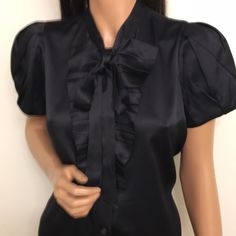 Authentic Prada Black Satin Silk Blouse. Size 42. Except Condition. No Issues. Short With Pleads. Front Banded Buttons Front Closure With Ruffles. Banded Collar With Long Ribbons For Lend Tie. Gorgeous Satin Silk Has Some Stretch. Bust- 38”, Waist-38”, Shoulders- 14”,Center Back Length-23”. Band Collar, Satin Silk, Blouse Top, Black Satin, Silk Blouse, Silk Satin, Ruffles, Prada, Top Blouse