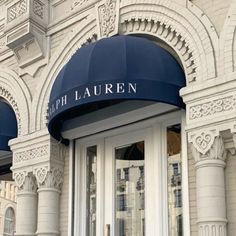 the front entrance of a building with blue awnings and white trim on it