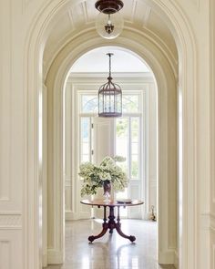 an archway leading to a dining room and living room with flowers in the vase on the table