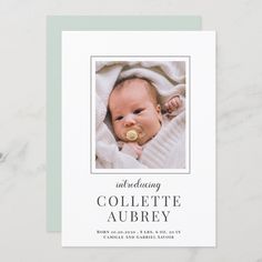 a birth announcement card with a photo of a baby in a blanket and pacifier