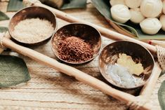 three bowls filled with different types of food on top of a wooden tray next to garlic