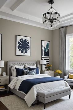 a bedroom decorated in shades of blue and gray with a chandelier hanging from the ceiling