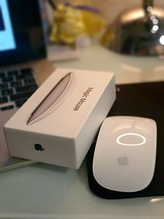 an apple mouse and box sitting on a desk