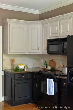 a kitchen with black cabinets and white cupboards is seen in this image from the front view