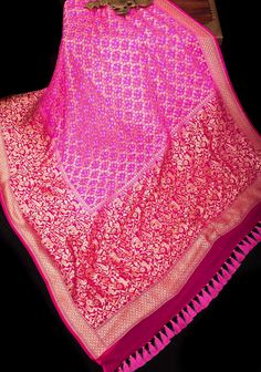 This custom-designed saree is beautified with the Bandhej work of Gujarat on a resplendent pure silk georgette saree from Banaras! Set in striking Pink, a close look at the Shikaargah pattern with an all-over Border of peacock, parrots,deer & Elephant is sure to wow you! Thousands of hand-plucked and resist-tied dots make it a piece of art! The pallu is equally resplendent with stunning motifs.  The fabric is pure georgette that is processed from pure silk yarns and woven to beauty, The saree is Unstitched Brocade Pre-draped Saree For Wedding, Bollywood Style Brocade Pre-draped Saree For Designer Wear, Pink Pre-draped Saree With Sheer Dupatta For Transitional Season, Semi-stitched Brocade Pre-draped Saree With Zari Work, Designer Brocade Saree For Eid, Brocade Pre-draped Saree With Dupatta For Wedding, Designer Unstitched Brocade Saree, Unstitched Designer Wear Saree In Brocade, Unstitched Designer Brocade Saree