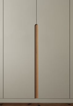 a tall wooden pole in the middle of a room with white walls and wood flooring