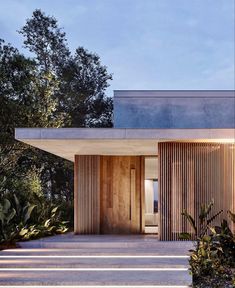 an entrance to a modern house with wooden slats on the walls and steps leading up to it