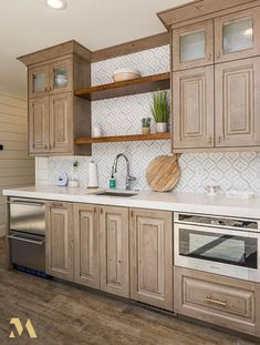 a kitchen with wooden cabinets and white counter tops, stainless steel dishwasher and oven