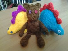 three knitted stuffed animals sitting on top of a wooden table