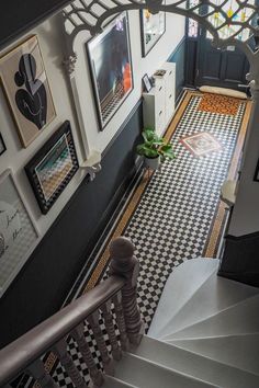 the stairs are decorated with black and white checkerboard flooring, framed pictures on the wall